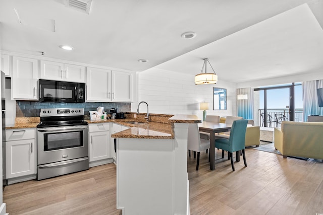 kitchen with stainless steel electric stove, kitchen peninsula, sink, decorative light fixtures, and white cabinetry