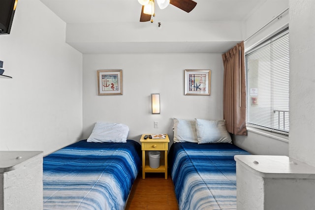 bedroom with multiple windows, ceiling fan, and hardwood / wood-style floors