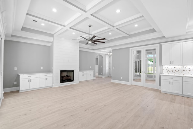 unfurnished living room featuring light hardwood / wood-style floors, a large fireplace, ceiling fan, beam ceiling, and coffered ceiling