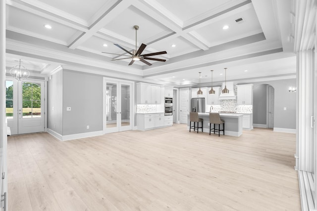 unfurnished living room with coffered ceiling, french doors, beamed ceiling, and ornamental molding