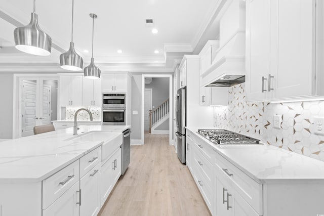 kitchen featuring white cabinetry, custom range hood, a large island, sink, and pendant lighting