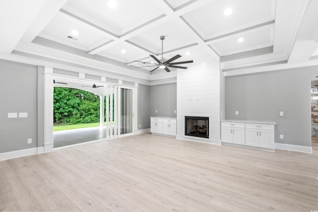 unfurnished living room featuring beamed ceiling, a fireplace, coffered ceiling, light hardwood / wood-style flooring, and ceiling fan