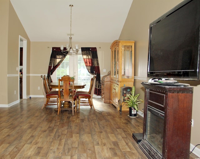 dining room featuring vaulted ceiling, a chandelier, and wood-type flooring