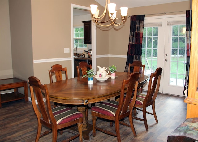 dining space with a notable chandelier, sink, dark hardwood / wood-style floors, and french doors