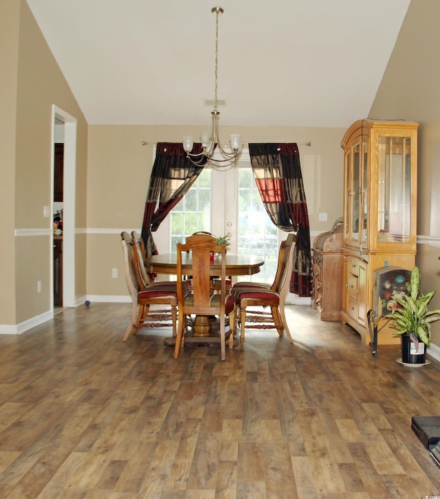 dining room featuring lofted ceiling, dark hardwood / wood-style floors, and a chandelier