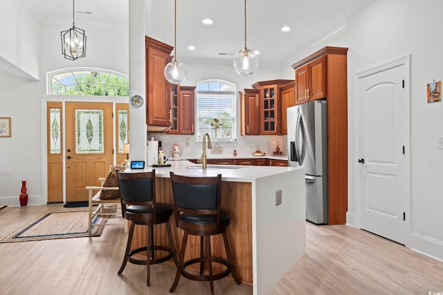 kitchen featuring plenty of natural light, pendant lighting, sink, and stainless steel refrigerator with ice dispenser