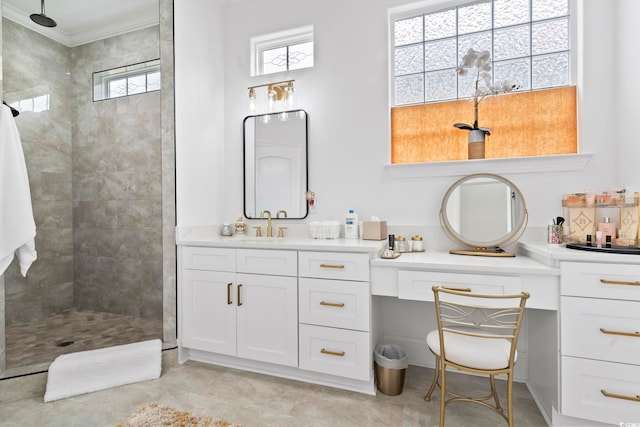 bathroom featuring a tile shower, crown molding, and vanity