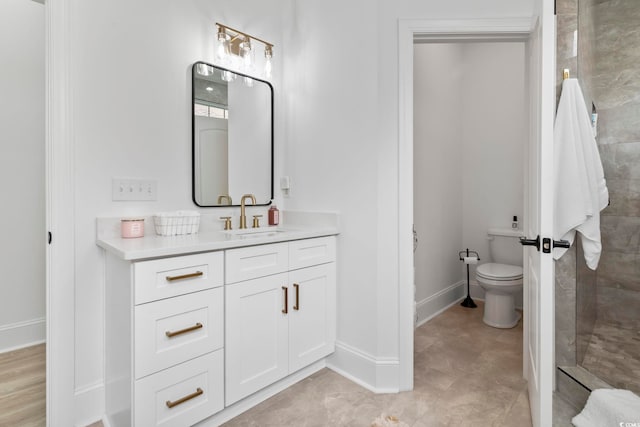 bathroom featuring tiled shower, vanity, and toilet