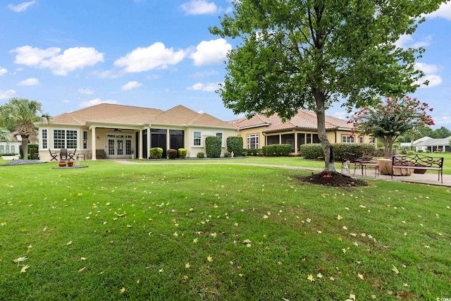 rear view of house featuring a yard and a patio