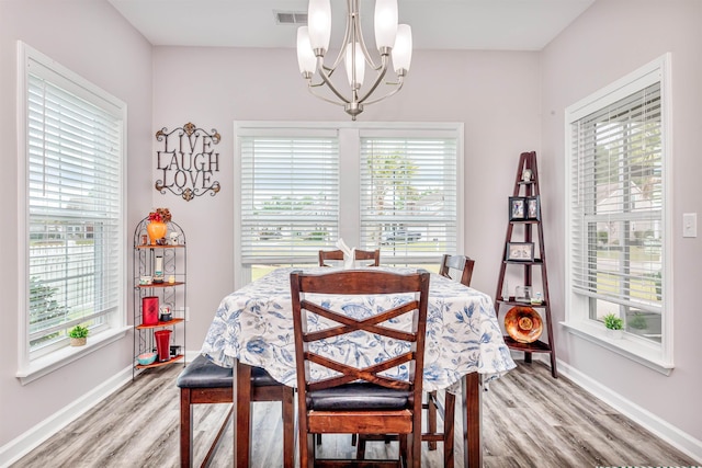 dining room with an inviting chandelier and light hardwood / wood-style flooring