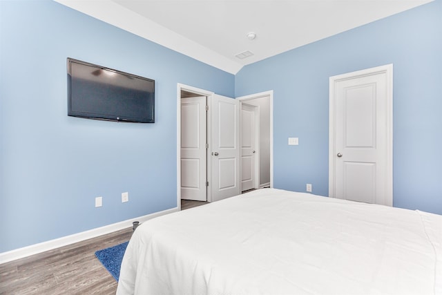 bedroom featuring lofted ceiling and hardwood / wood-style floors