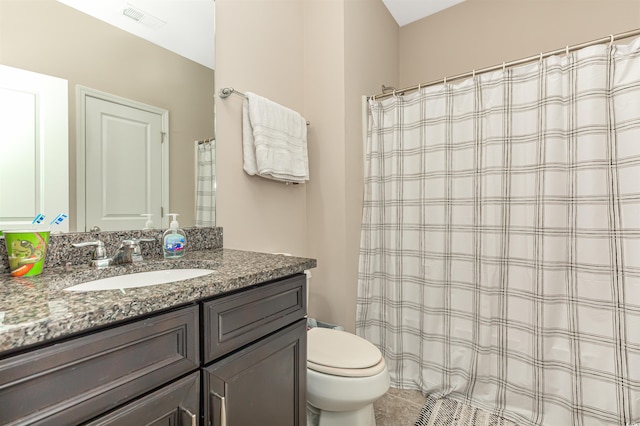 bathroom with curtained shower, vanity, and toilet