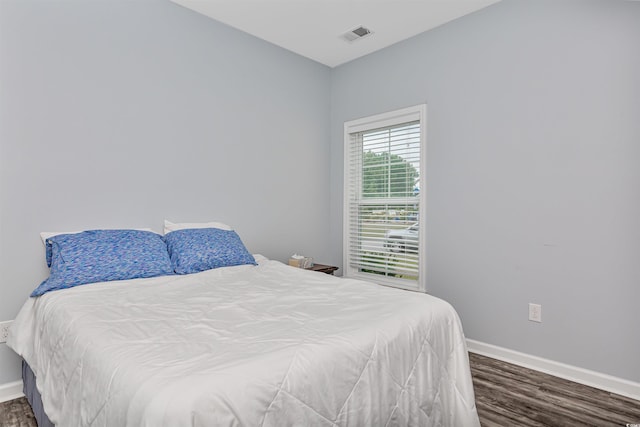 bedroom with dark hardwood / wood-style floors