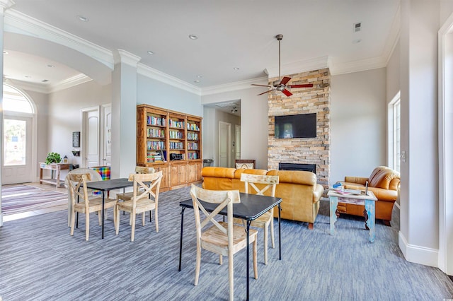 dining space with crown molding, a fireplace, ceiling fan, and hardwood / wood-style floors