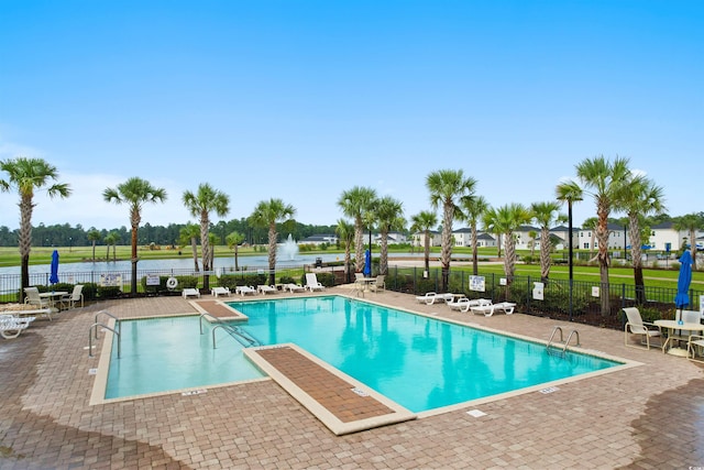 view of pool featuring a water view and a patio