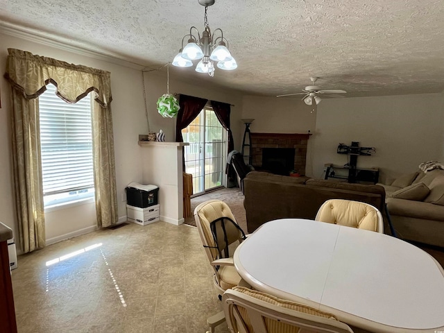 dining area featuring a textured ceiling, light tile patterned floors, a brick fireplace, and ceiling fan with notable chandelier