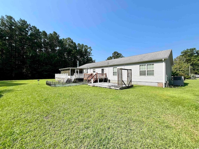 back of property featuring a deck and a yard