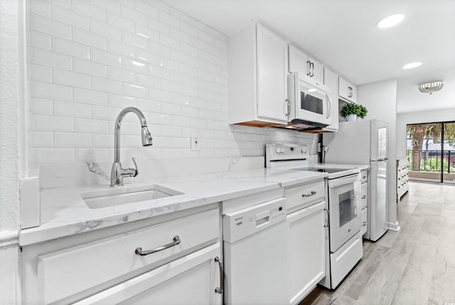 unfurnished bedroom featuring multiple windows, light wood-type flooring, and access to outside