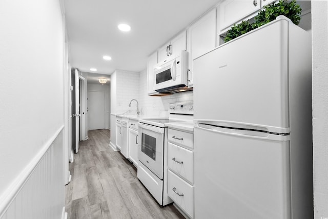 kitchen with white appliances, light hardwood / wood-style flooring, white cabinetry, and tasteful backsplash