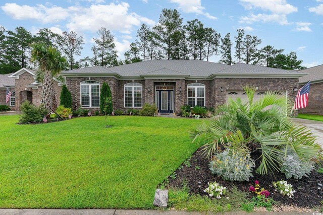 ranch-style house featuring a garage and a front lawn