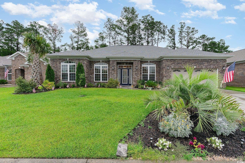 ranch-style house featuring a garage and a front lawn