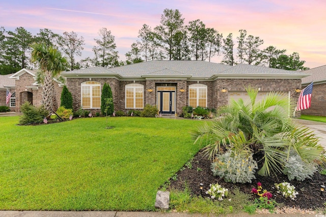 ranch-style home with a garage and a lawn