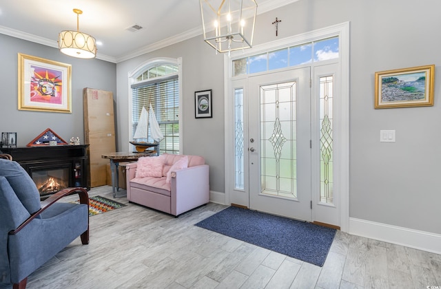 foyer featuring wood-type flooring, crown molding, and a chandelier