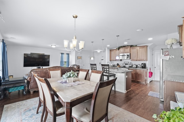 dining area with dark wood-style floors, a chandelier, and recessed lighting