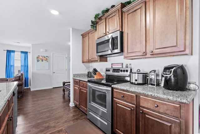 kitchen with baseboards, light stone countertops, recessed lighting, appliances with stainless steel finishes, and dark wood-style floors
