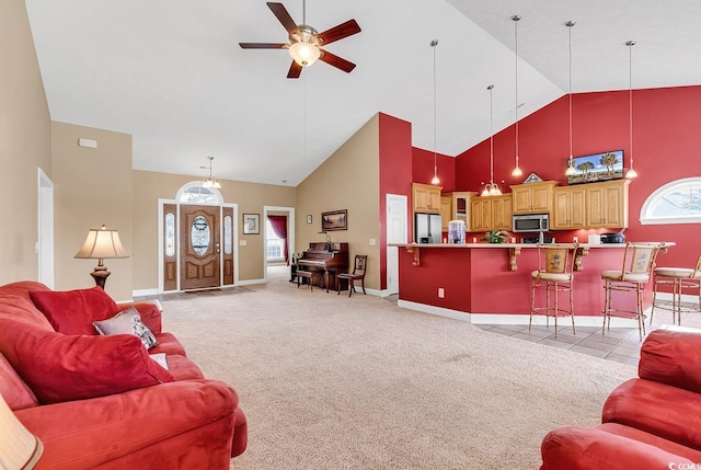 living room featuring high vaulted ceiling, light colored carpet, and ceiling fan