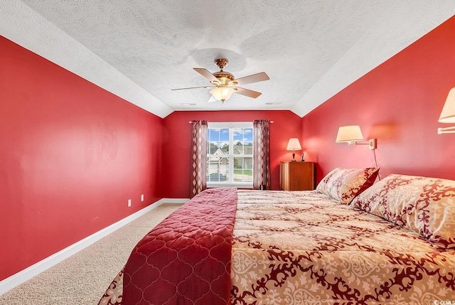 carpeted bedroom featuring vaulted ceiling, a textured ceiling, and ceiling fan