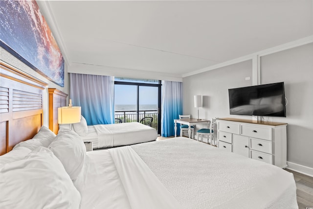 bedroom featuring a wall of windows, baseboards, crown molding, and access to outside