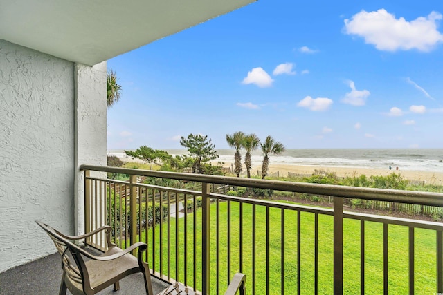 balcony featuring a view of the beach and a water view