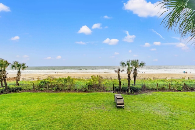 view of yard with a beach view, a water view, and fence