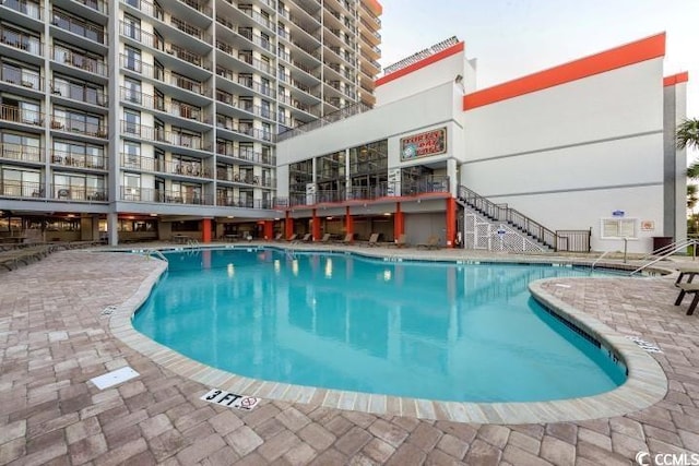 pool featuring a patio area and stairway