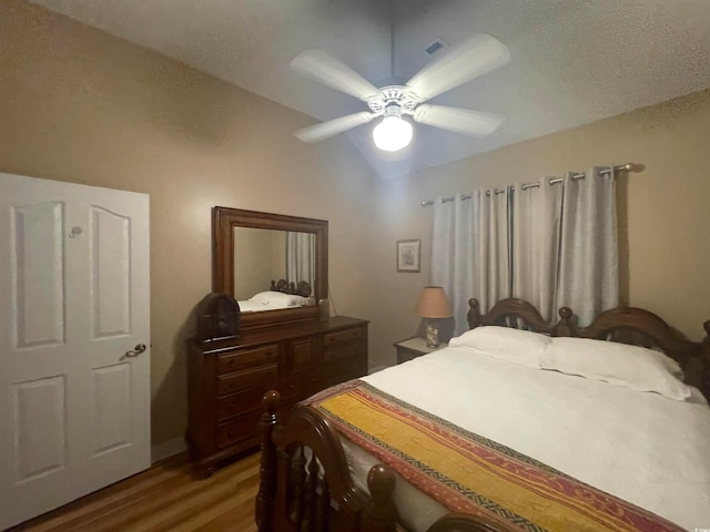 bedroom with lofted ceiling, hardwood / wood-style floors, and ceiling fan