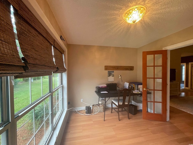 office featuring a textured ceiling, french doors, and light wood-type flooring