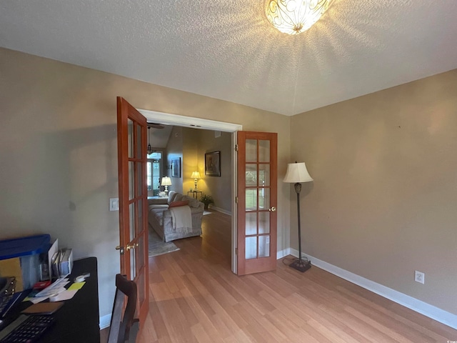 home office with hardwood / wood-style flooring, french doors, and a textured ceiling