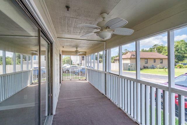 unfurnished sunroom with ceiling fan