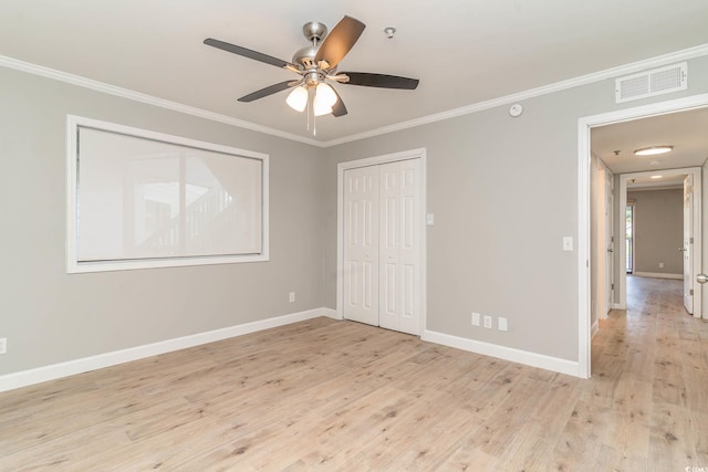 unfurnished bedroom featuring ceiling fan, crown molding, light hardwood / wood-style flooring, and a closet