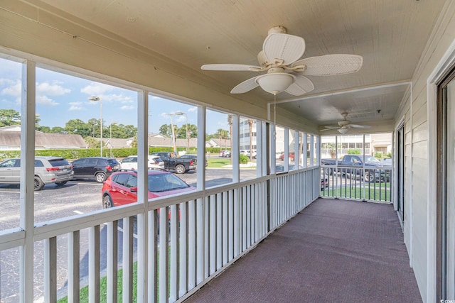 unfurnished sunroom with ceiling fan