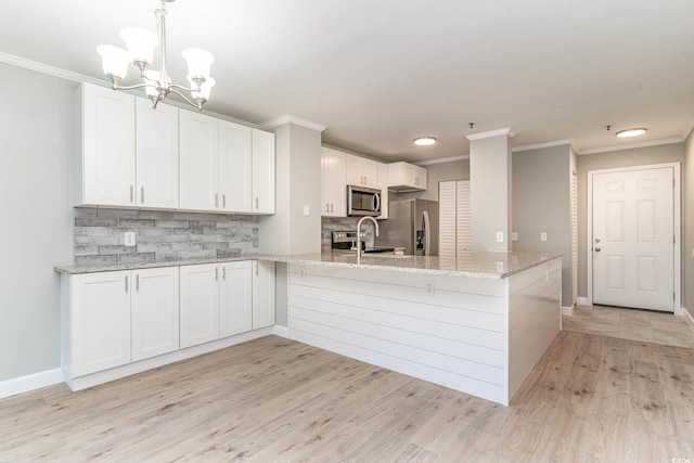 kitchen with white cabinetry, light stone counters, light wood-type flooring, and stainless steel appliances