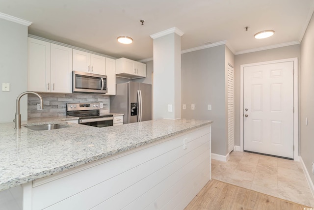 kitchen featuring light hardwood / wood-style floors, light stone counters, appliances with stainless steel finishes, and sink