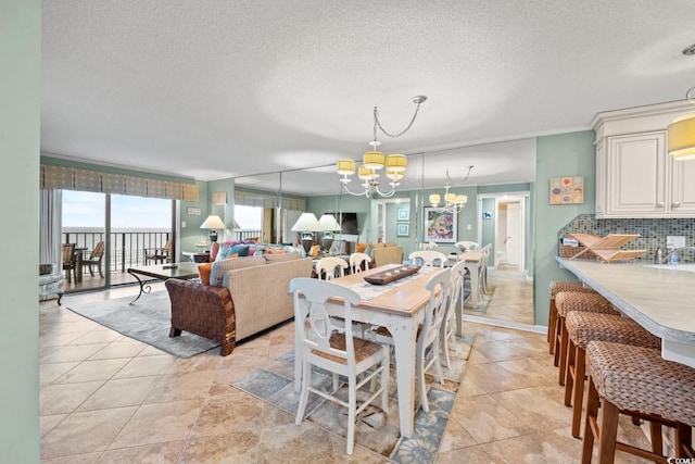 tiled dining space featuring a chandelier, a textured ceiling, and ornamental molding