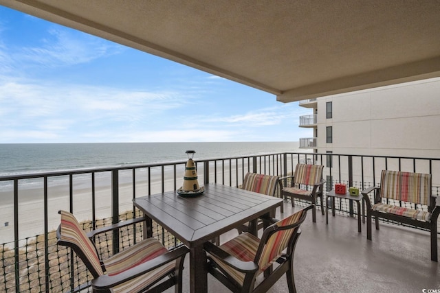 balcony featuring a water view and a beach view