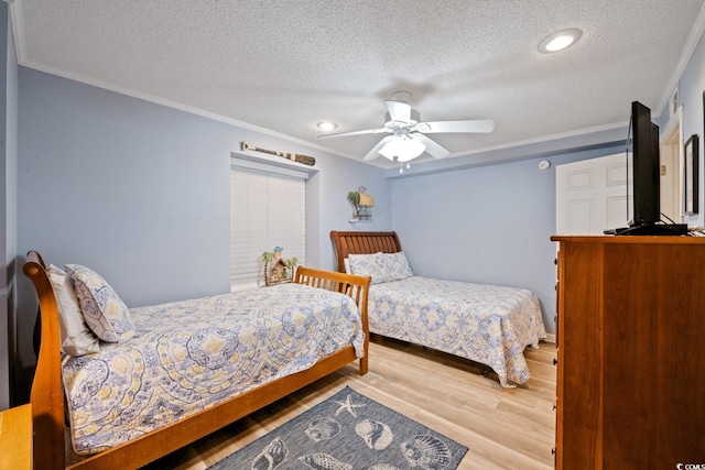 bedroom featuring wood-type flooring, a textured ceiling, ceiling fan, and ornamental molding