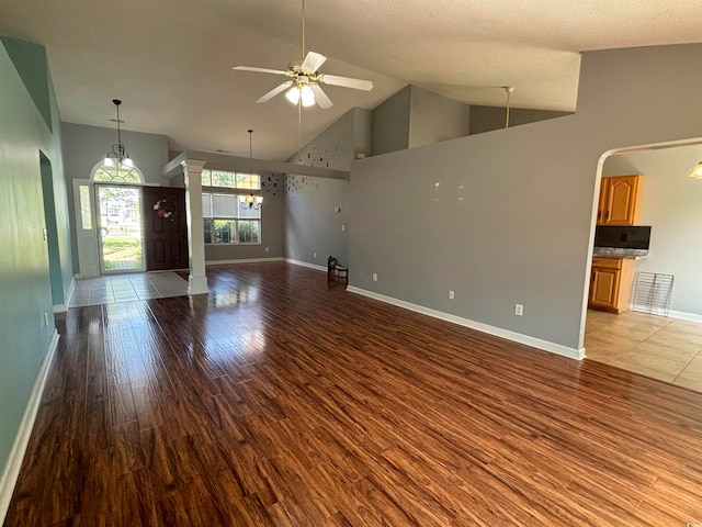 unfurnished living room featuring light hardwood / wood-style floors, a textured ceiling, decorative columns, high vaulted ceiling, and ceiling fan