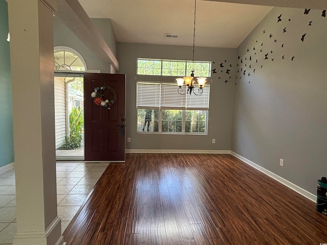 foyer entrance featuring hardwood / wood-style flooring, a chandelier, and a high ceiling