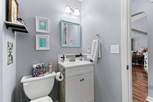 bathroom with hardwood / wood-style flooring, vanity, and toilet