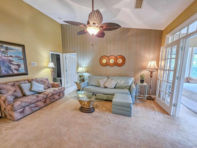 carpeted living room with high vaulted ceiling, ceiling fan, and a textured ceiling